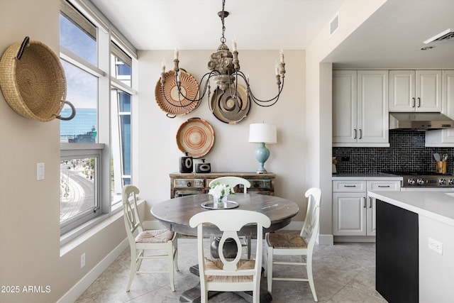 dining room with a chandelier, baseboards, and light tile patterned floors