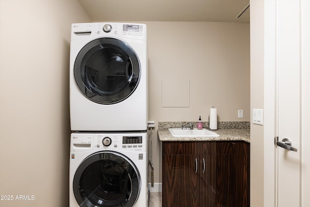laundry room featuring estacked washer and dryer and cabinet space