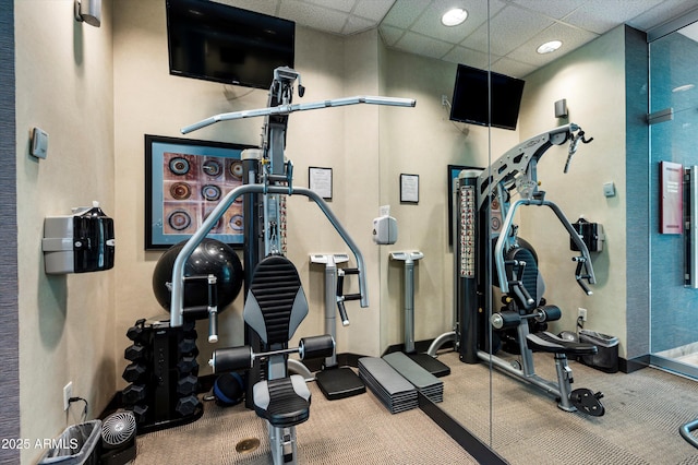 workout area featuring carpet and a paneled ceiling