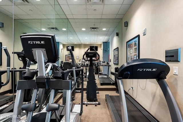 gym with a paneled ceiling, carpet, and recessed lighting