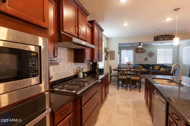 19937 W Heatherbrae Dr, Litchfield Park, AZ 85340 - kitchen with a sink, stainless steel appliances, under cabinet range hood, backsplash, and dark stone countertops