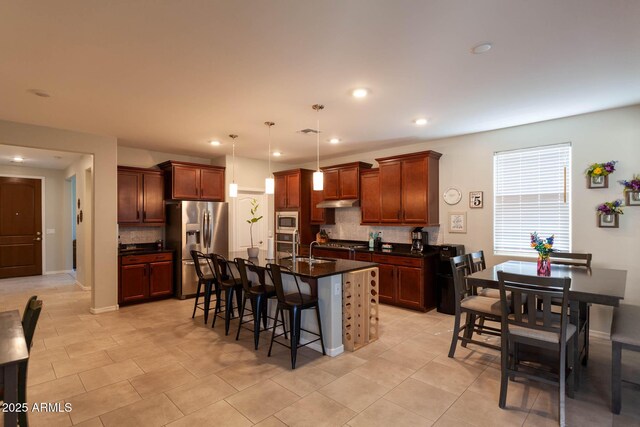 19937 W Heatherbrae Dr, Litchfield Park, AZ 85340 - kitchen with appliances with stainless steel finishes, dark countertops, decorative backsplash, a breakfast bar, and a sink