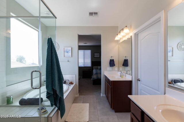 19937 W Heatherbrae Dr, Litchfield Park, AZ 85340 - ensuite bathroom featuring two vanities, a shower stall, a garden tub, and tile patterned flooring