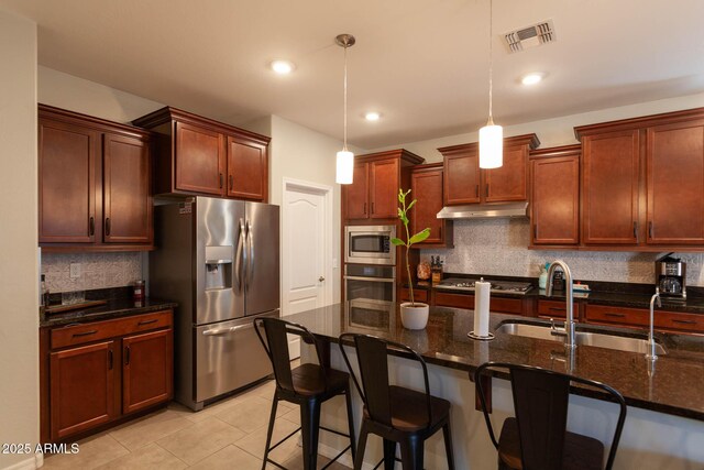 19937 W Heatherbrae Dr, Litchfield Park, AZ 85340 - kitchen with appliances with stainless steel finishes, a sink, backsplash, a breakfast bar area, and hanging light fixtures