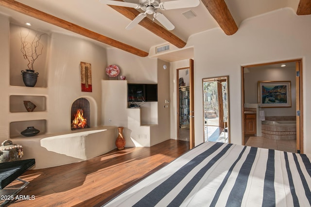 bedroom with beamed ceiling and hardwood / wood-style floors