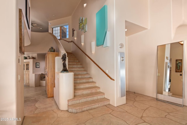 stairs featuring a towering ceiling