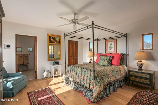 bedroom featuring connected bathroom and light hardwood / wood-style flooring