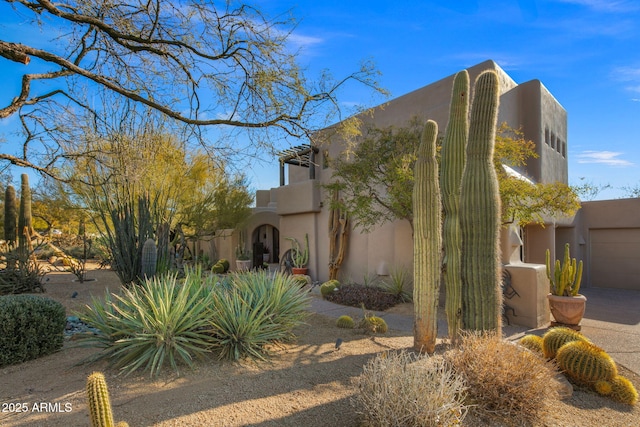 pueblo revival-style home featuring a garage