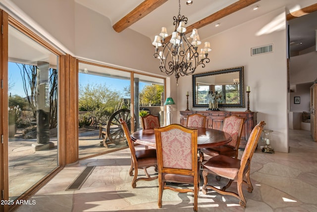 dining room with an inviting chandelier, a towering ceiling, and beam ceiling