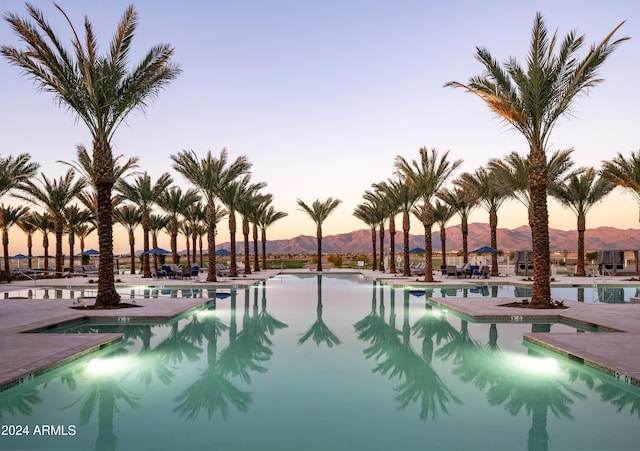 pool at dusk featuring a mountain view