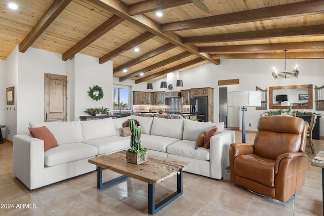 living room with vaulted ceiling with beams, light tile patterned floors, wooden ceiling, and a notable chandelier