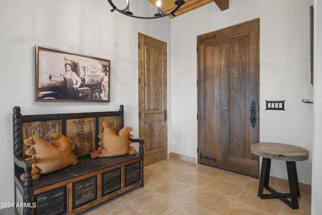 entryway with light tile patterned floors and an inviting chandelier