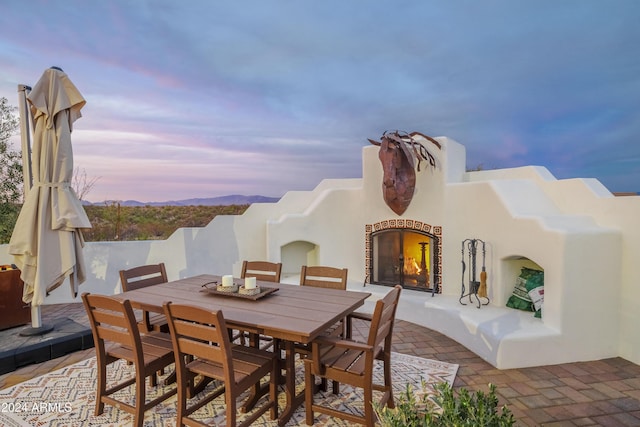 patio terrace at dusk with exterior fireplace