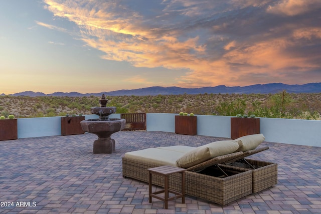 patio terrace at dusk featuring a mountain view