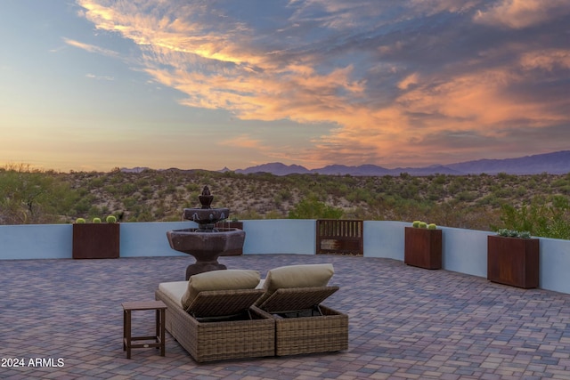 patio terrace at dusk featuring a mountain view