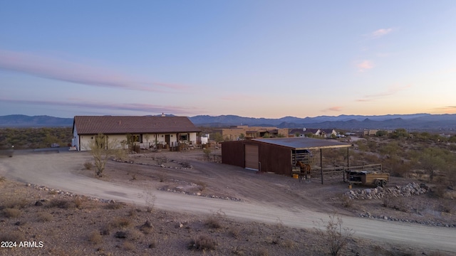 view of front of property with a mountain view and an outdoor structure