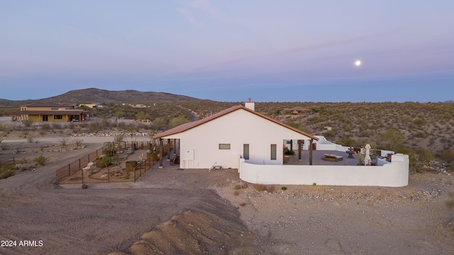 property exterior at dusk with a mountain view