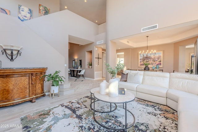 10772 E Running Deer Trl, Scottsdale, AZ 85262 - living room with a chandelier, wood finished floors, a towering ceiling, baseboards, and recessed lighting