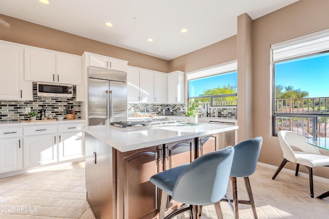 10772 E Running Deer Trl, Scottsdale, AZ 85262 - kitchen featuring stainless steel appliances, tasteful backsplash, recessed lighting, white cabinetry, and a center island