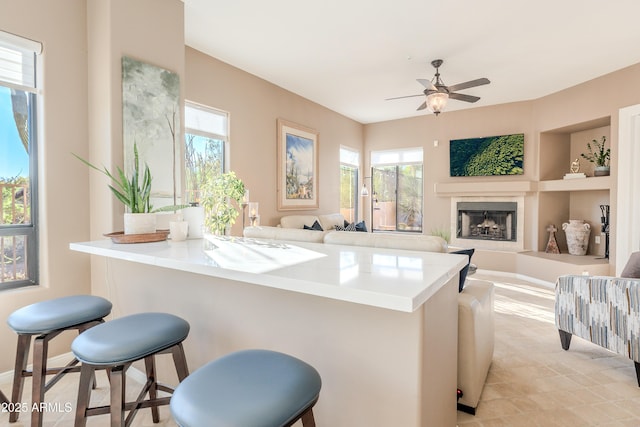 10772 E Running Deer Trl, Scottsdale, AZ 85262 - kitchen with a kitchen bar, a fireplace, healthy amount of natural light, and a ceiling fan