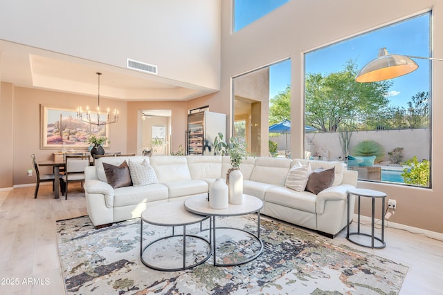 10772 E Running Deer Trl, Scottsdale, AZ 85262 - living room with wood finished floors, a chandelier, baseboards, and a tray ceiling