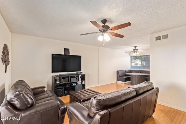 living room featuring a textured ceiling and light hardwood / wood-style flooring