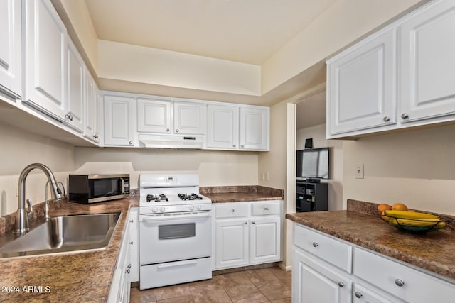 kitchen featuring white gas range, sink, white cabinets, and light tile patterned floors