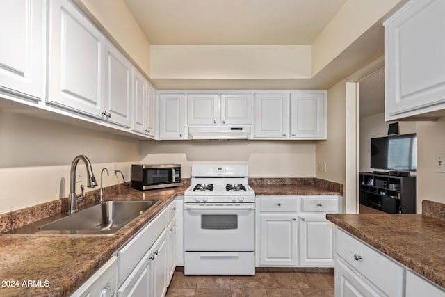 kitchen featuring white gas range, white cabinetry, sink, and light tile patterned floors