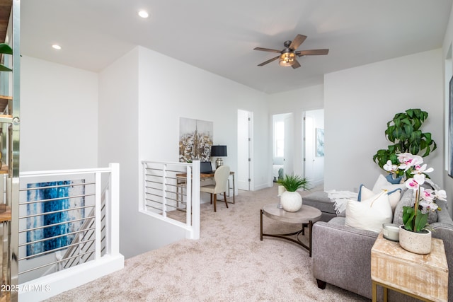 carpeted living room with ceiling fan