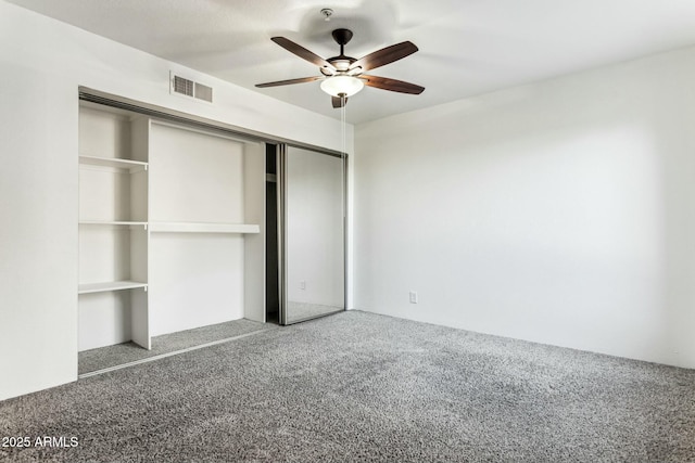 unfurnished bedroom with ceiling fan, carpet, and a closet