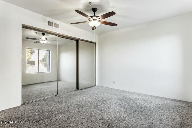 unfurnished bedroom featuring carpet floors, a closet, and ceiling fan