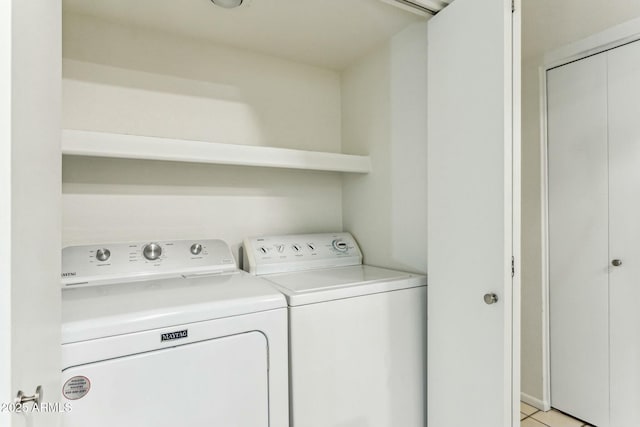 laundry room featuring independent washer and dryer and light tile patterned floors