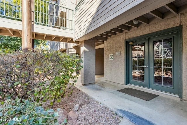 view of exterior entry with stucco siding and french doors