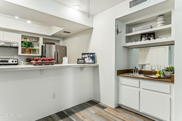 kitchen with sink, white cabinetry, light hardwood / wood-style flooring, and appliances with stainless steel finishes