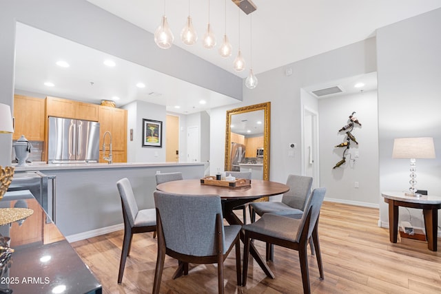 dining room featuring sink and light wood-type flooring