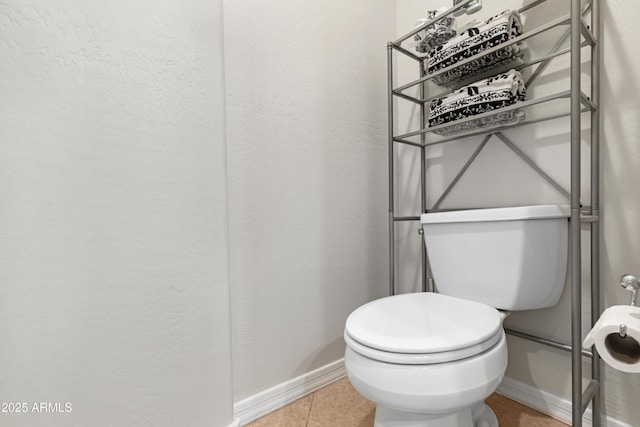 bathroom featuring tile patterned flooring, toilet, and baseboards