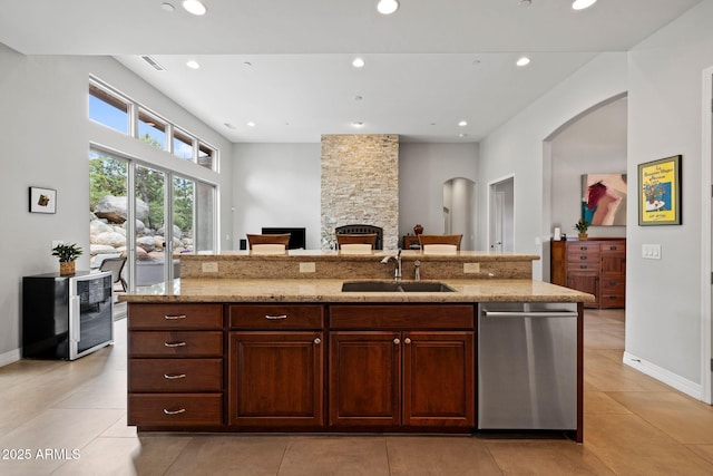 1385 Ridgewood Dr, Prescott, AZ 86305 - kitchen with dishwasher, a sink, arched walkways, a stone fireplace, and light stone countertops