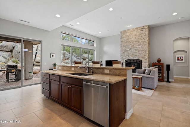 1385 Ridgewood Dr, Prescott, AZ 86305 - kitchen with stainless steel dishwasher, a sink, arched walkways, a fireplace, and light stone countertops