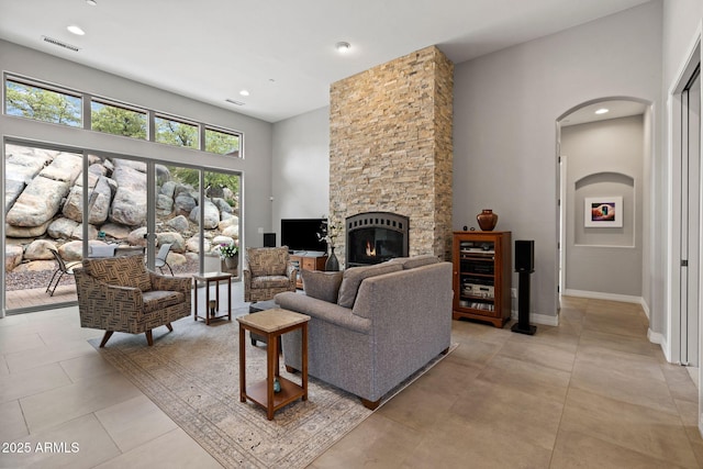 1385 Ridgewood Dr, Prescott, AZ 86305 - living room with a stone fireplace, arched walkways, recessed lighting, a towering ceiling, and baseboards