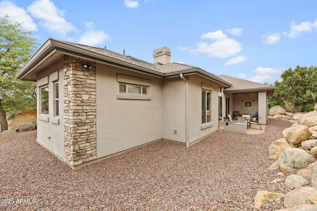 1385 Ridgewood Dr, Prescott, AZ 86305 - view of home's exterior with stone siding, a chimney, stucco siding, and a patio area