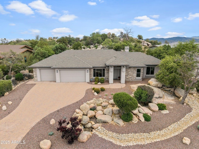1385 Ridgewood Dr, Prescott, AZ 86305 - prairie-style house featuring a garage, driveway, stone siding, and a mountain view