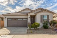 ranch-style home with an attached garage and concrete driveway