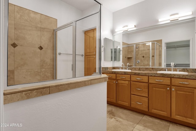 bathroom featuring tile patterned flooring, vanity, and a shower with shower door