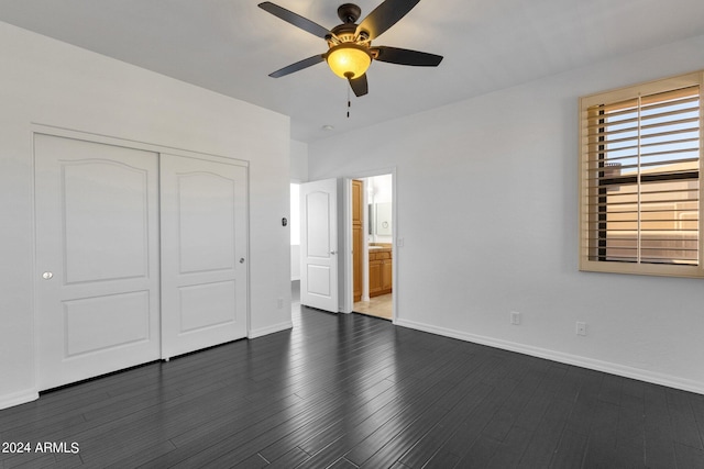 unfurnished bedroom featuring dark hardwood / wood-style flooring, ceiling fan, a closet, and ensuite bath