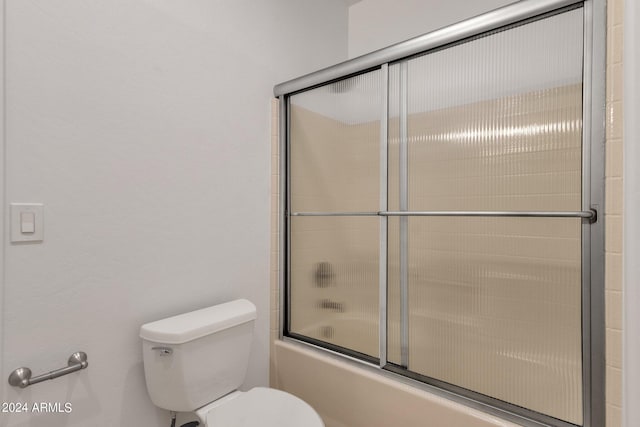 bathroom with shower / bath combination with glass door and toilet