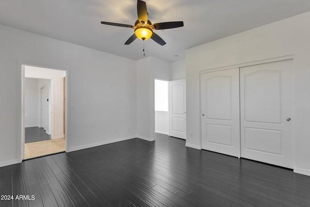 unfurnished bedroom with dark hardwood / wood-style floors, ceiling fan, and a closet