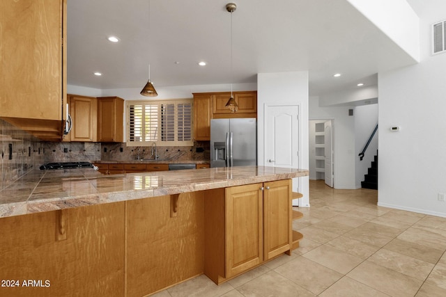 kitchen with a kitchen bar, kitchen peninsula, pendant lighting, and appliances with stainless steel finishes