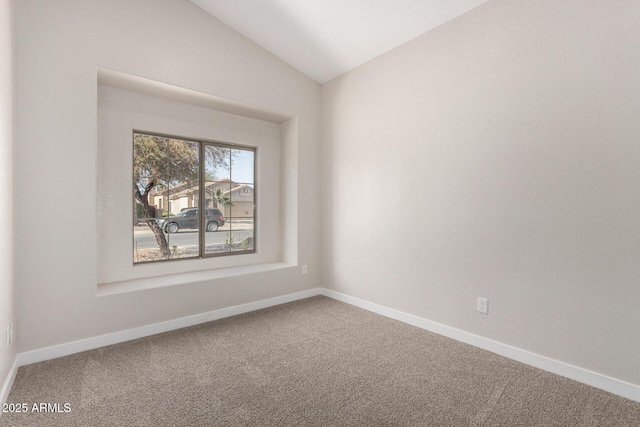 unfurnished room with vaulted ceiling and carpet