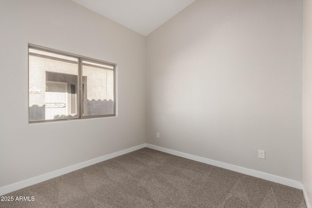 carpeted spare room featuring lofted ceiling