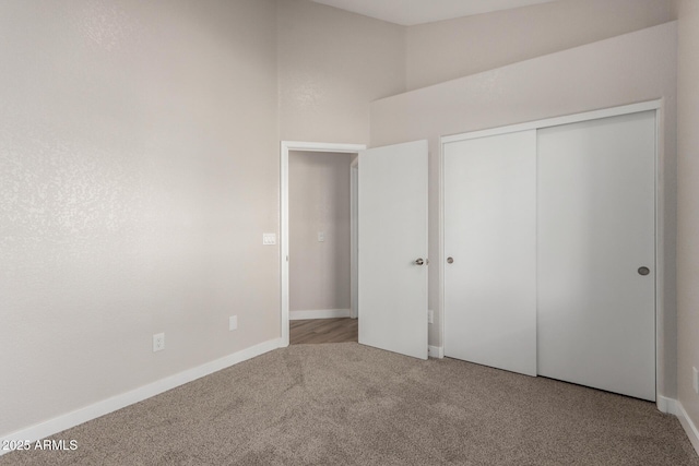 unfurnished bedroom featuring a closet and light colored carpet